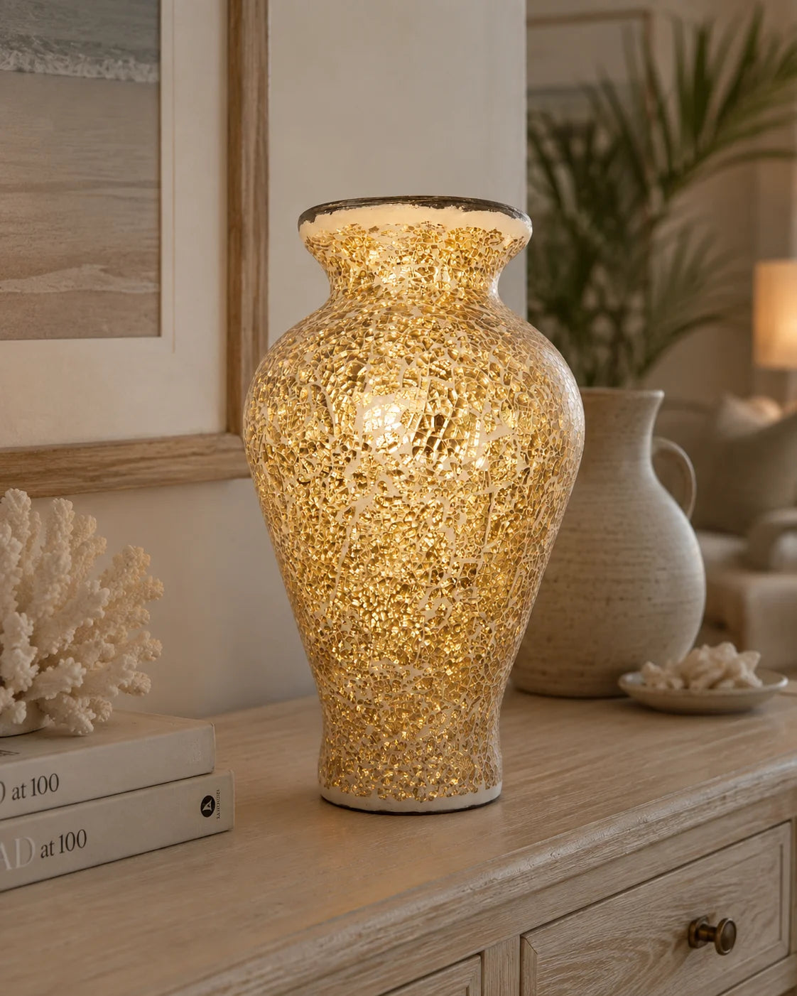 Sun-inspired gold mosaic statement vase styled on a timber console in a warm coastal home