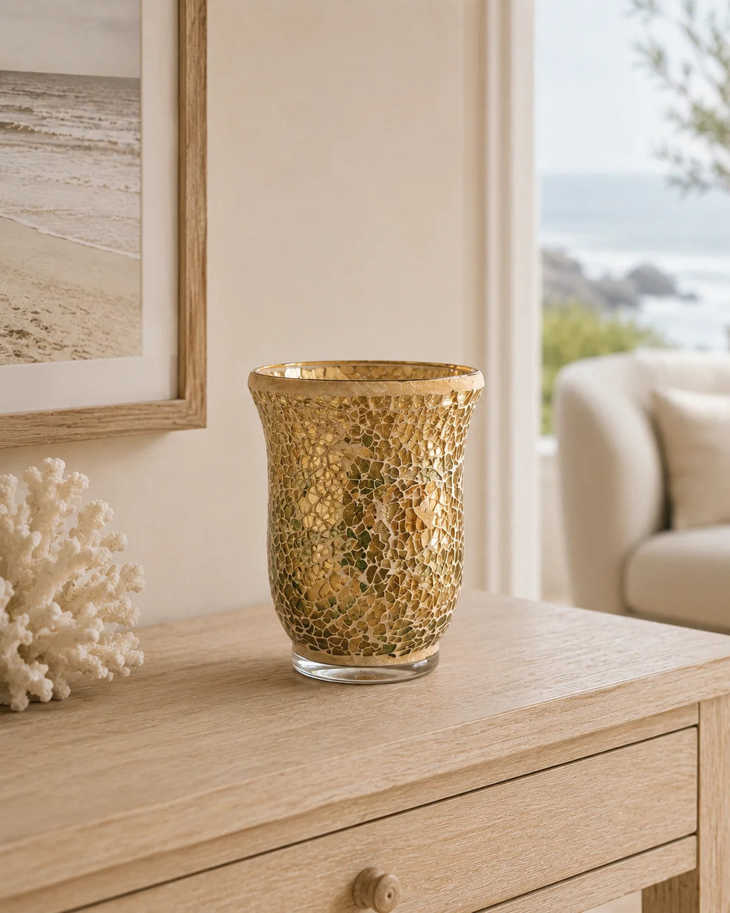 Gold mosaic candle holder styled on a light timber console in a coastal home